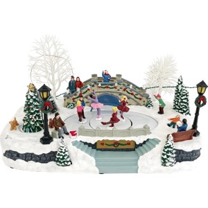 Beleuchtetes Weihnachtsdorf mit Eislaufbahn, Figuren, Brücke, Bäumen und Schnee. Winterliche Weihnachtsdekoration.
