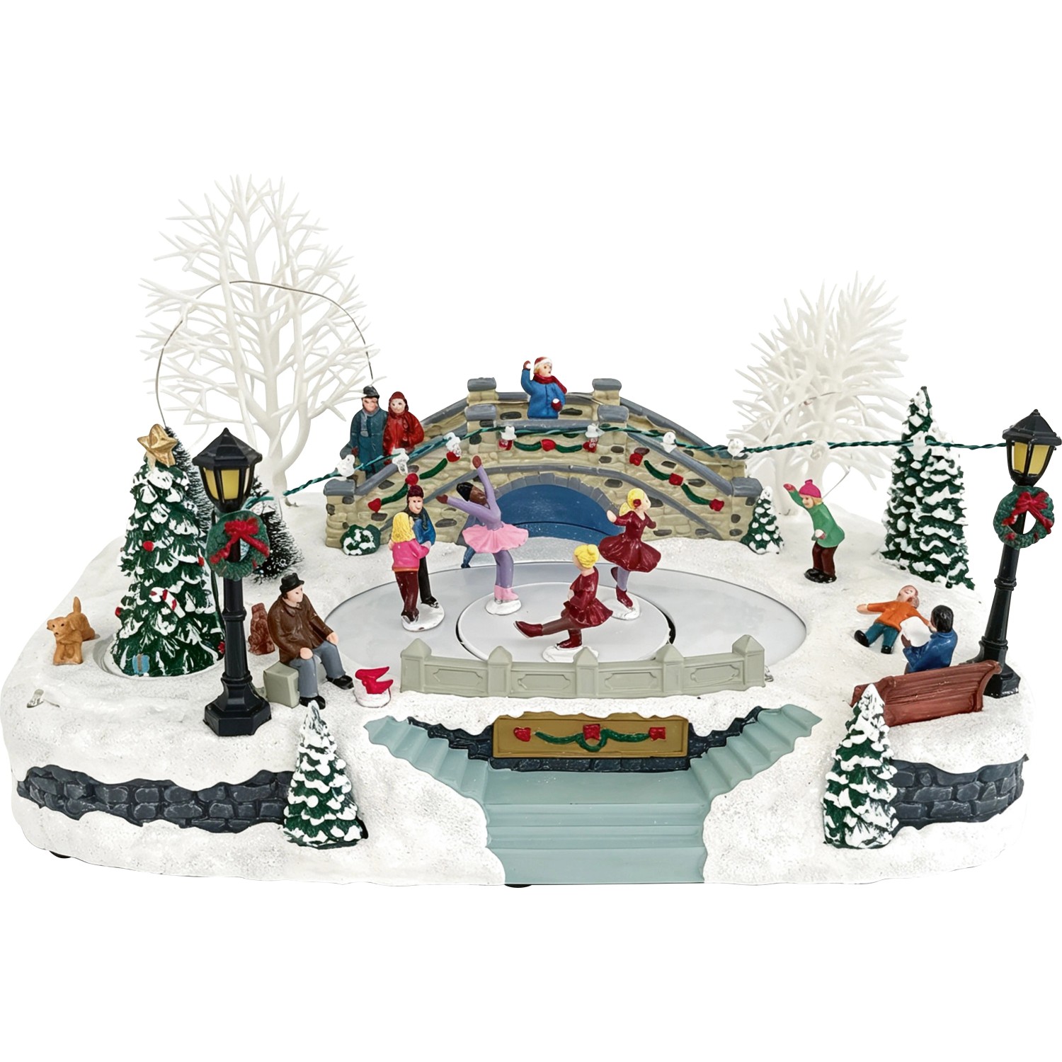 Beleuchtetes Weihnachtsdorf mit Eislaufbahn, Figuren, Brücke, Bäumen und Schnee. Winterliche Weihnachtsdekoration.
