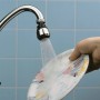 Verchromte Küchenbrause M22/M24 am Wasserhahn beim Abspülen eines Tellers.