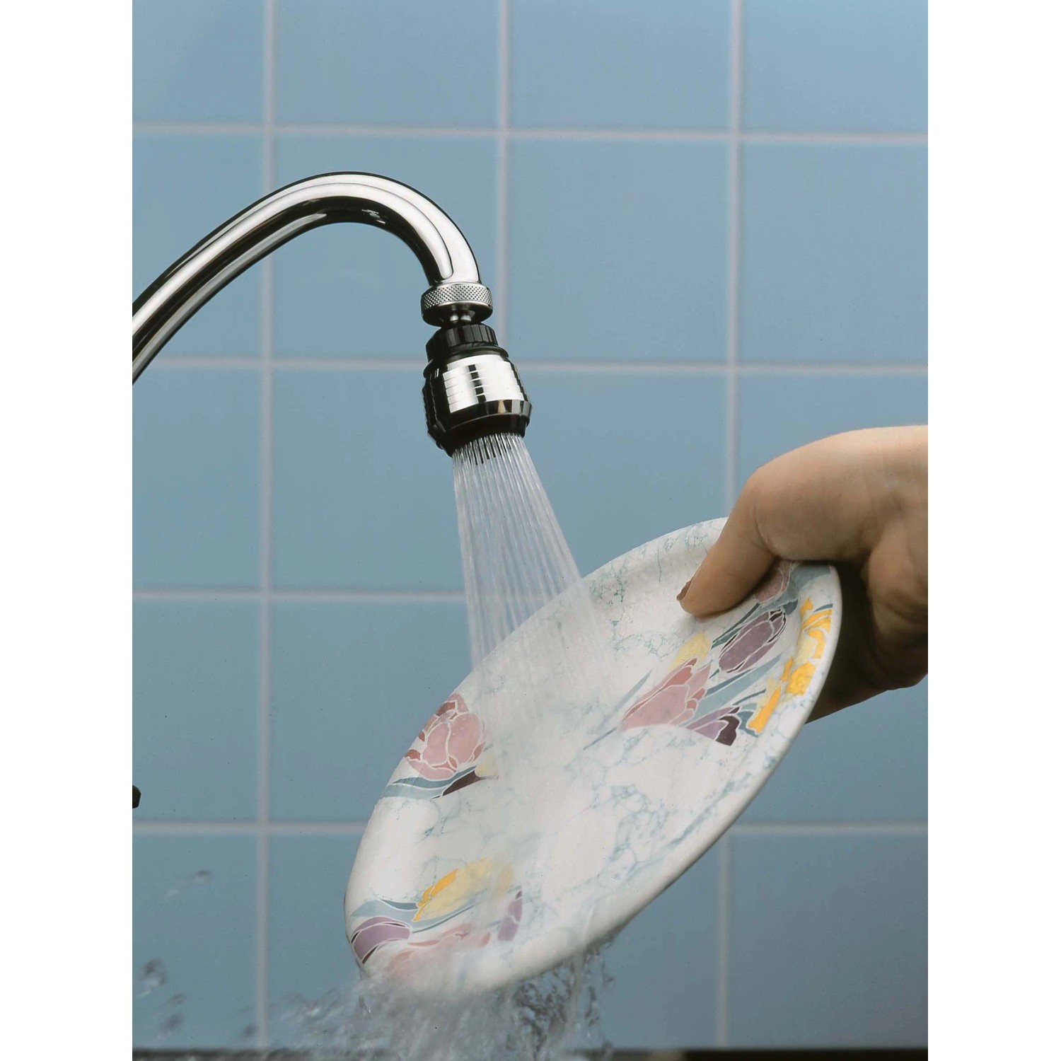 Verchromte Küchenbrause M22/M24 am Wasserhahn beim Abspülen eines Tellers.