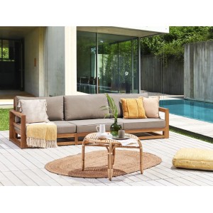 Beliani Gartensofa aus Holz mit graubeigen Kissen, kombiniert mit einem Rattantisch und Dekoration.