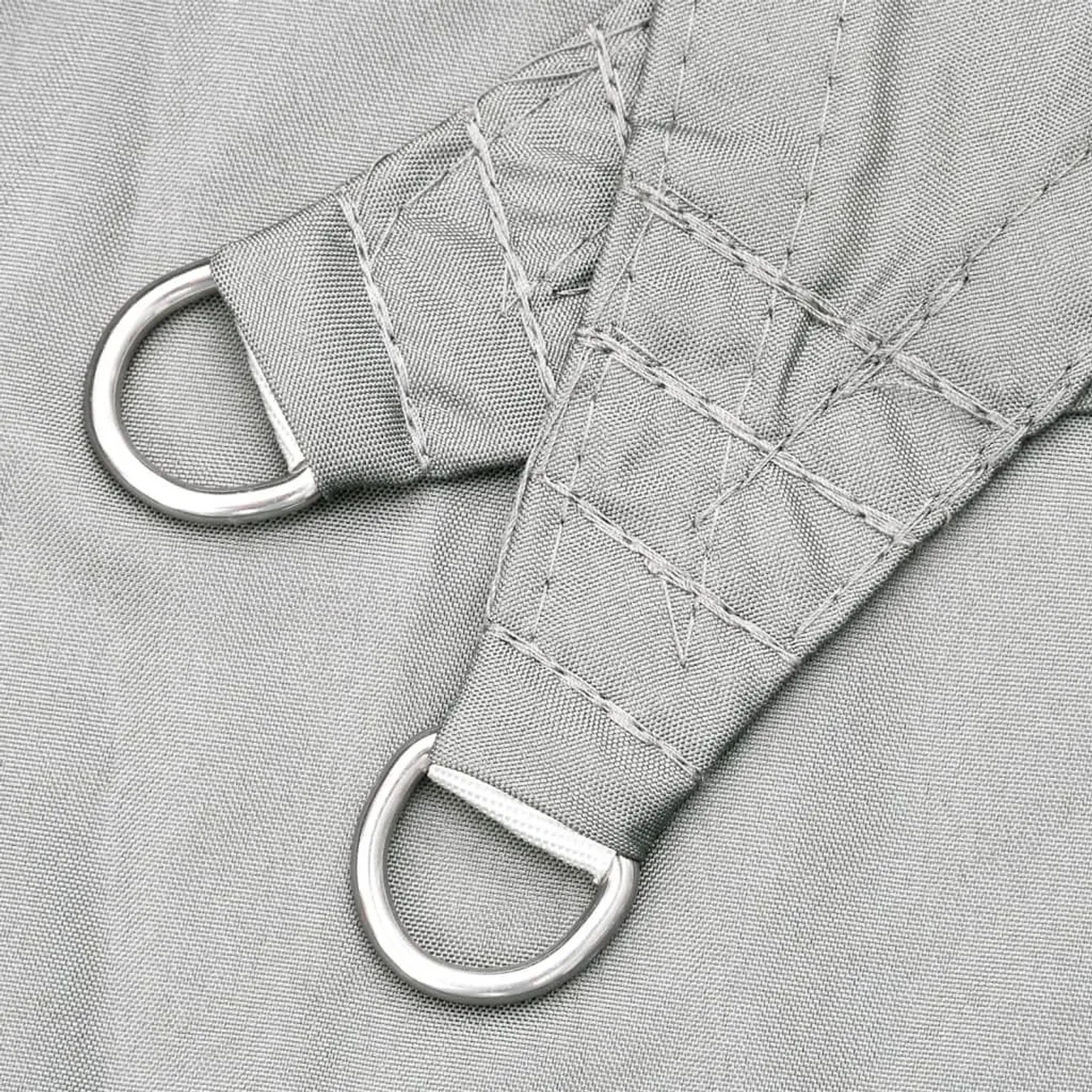 Nahaufnahme der verstärkten Ecke eines hellgrauen Sonnensegels mit robustem D-Ring aus Metall zur Befestigung.