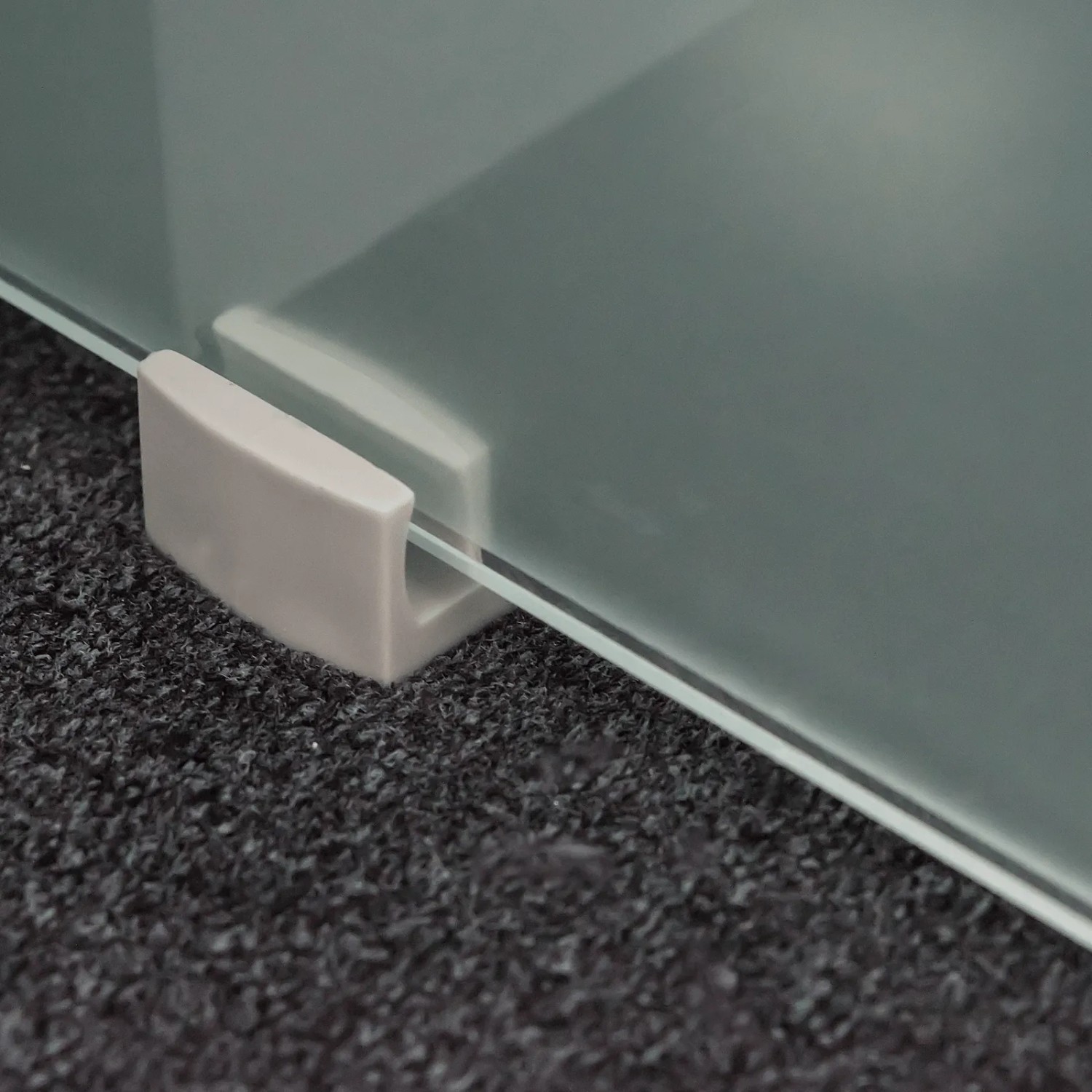 Detailaufnahme: Satinierte Glasschiebetür mit "Kitchen" Schriftzug und Bodenführung.