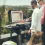 Severin Standgrill PG 8139: Elektrogrill mit Grillgut und zwei Personen im Garten.