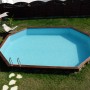 Ovaler Gre Echtholzpool Grenade 2, 436x336x117 cm, mit Leiter im Garten.
