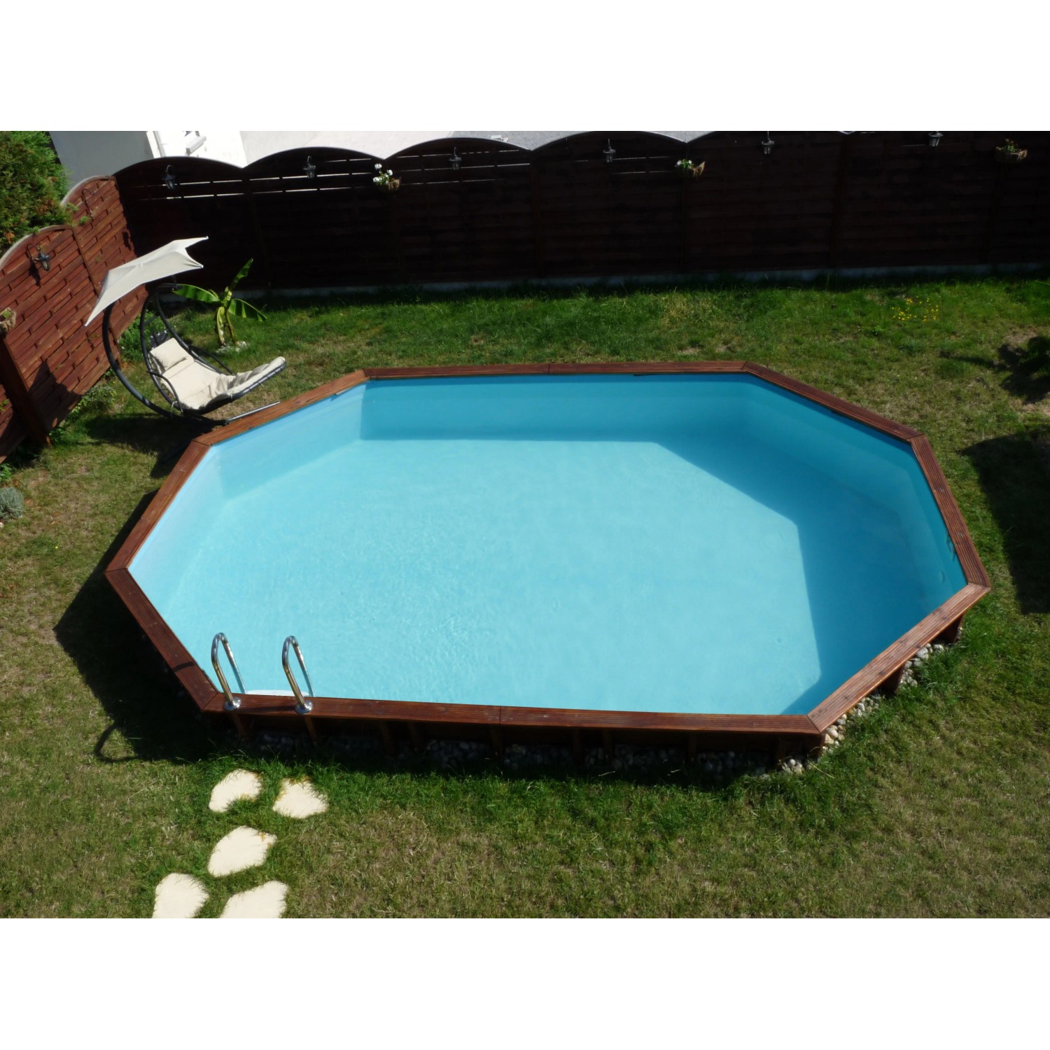 Ovaler Gre Echtholzpool Grenade 2, 436x336x117 cm, mit Leiter im Garten.