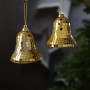 Zwei goldene Christbaumschmuck-Glocken im Discokugel-Look mit Glitzer-Effekt hängen vor einem Weihnachtsbaum.