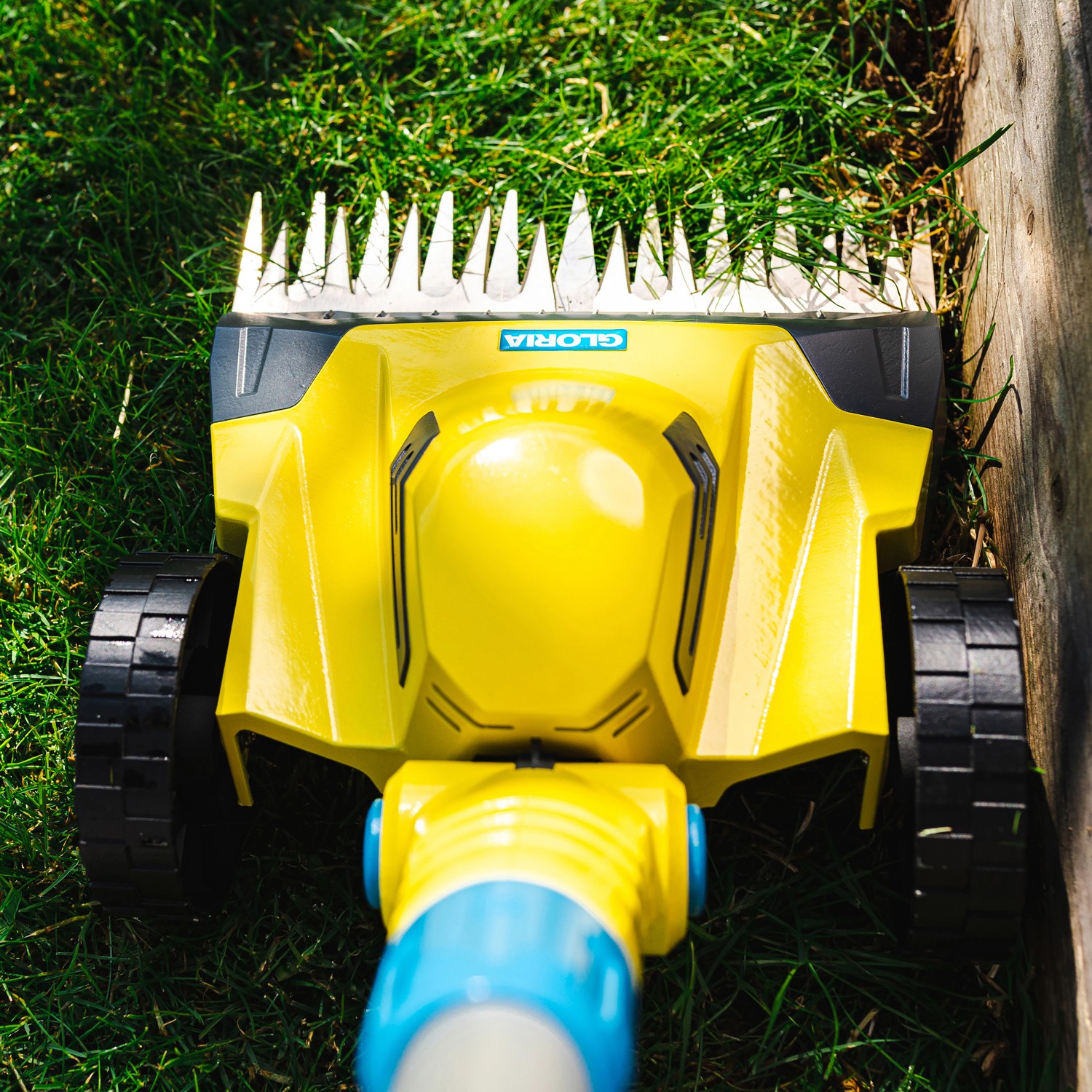 Gelber Gloria Akku-Rasentrimmer Finecut 18V schneidet Rasenkante. Ideal für Gartenarbeiten.