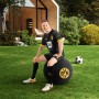 Mann sitzt auf schwarzem BVB Sitting Ball Hocker 120l im Garten.