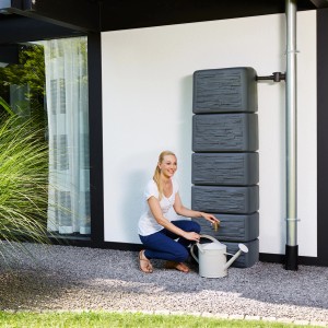 Graue 4rain Zisterne Slim Stone Decor Regentonne (330 l) mit Frau und Gießkanne.