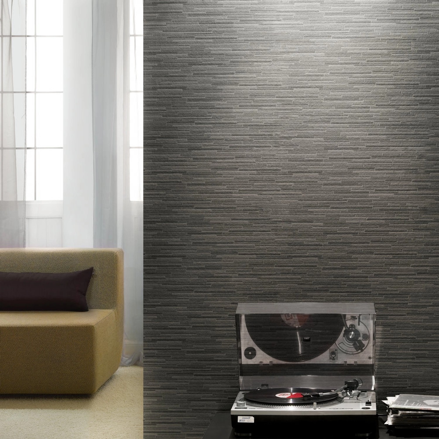 A.S. Création Vliestapete Best of Wood´n Stone Steinriemchen Grau an Wand mit Sofa und Plattenspieler.