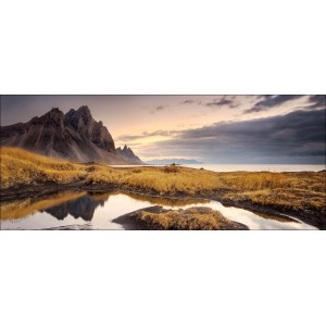 Deco Panel Anonymus Morningrise: Landschaft mit Bergen, Wasser und gelbem Gras. Wandbild im Panoramaformat.