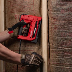Roter Arrow Elektrotacker ET501F beim Befestigen einer Holzleiste an einer Wand.