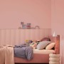Zimmer in Altrosa mit Alpina Wandfarbe Pure Farben Altrosa und Bett.