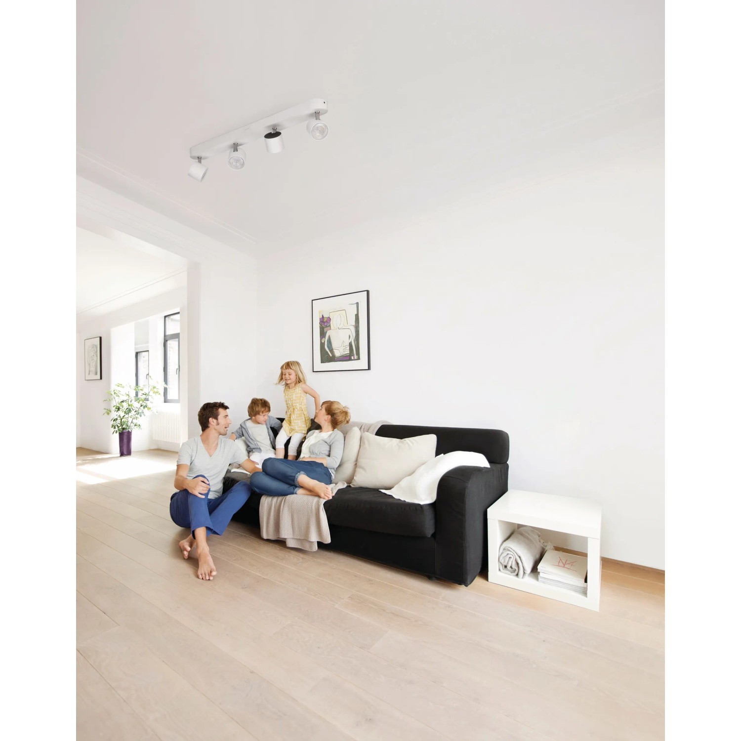Philips LED-Spot 4er Star Weiß im Wohnzimmer mit Familie unter der Lampe.