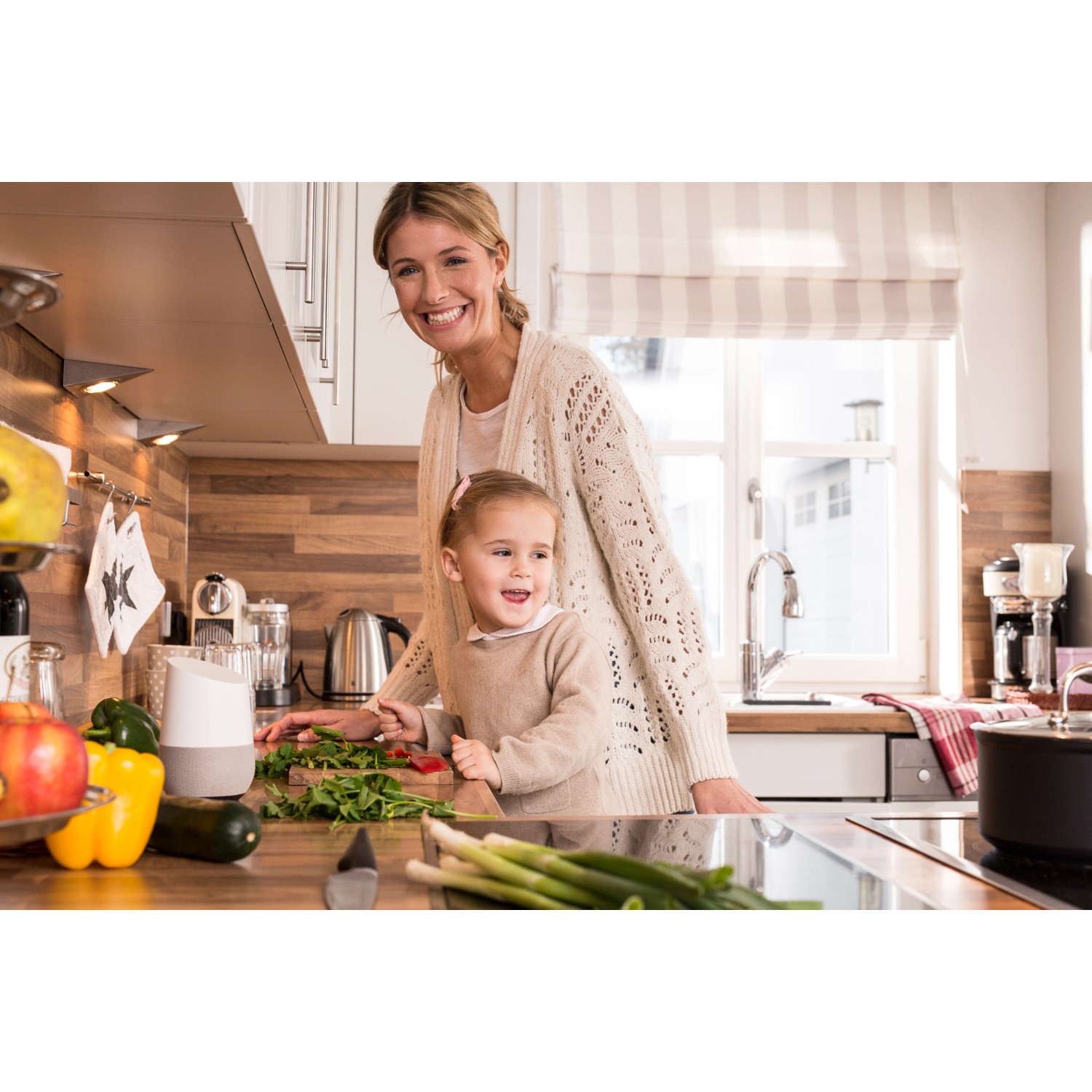 Frau und Kind bereiten Essen in der Küche zu. Verschiedene Zutaten liegen auf der Arbeitsfläche.