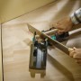Wolfcraft Schmiege und Gehrungsschneidlade im Einsatz mit Handsäge für präzise Gehrungsschnitte.