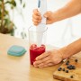 Rotho Küchenhelfer Loft: 5-in-1 Messbecher transparent mit grünem Deckel und Stabmixer in Nutzung.