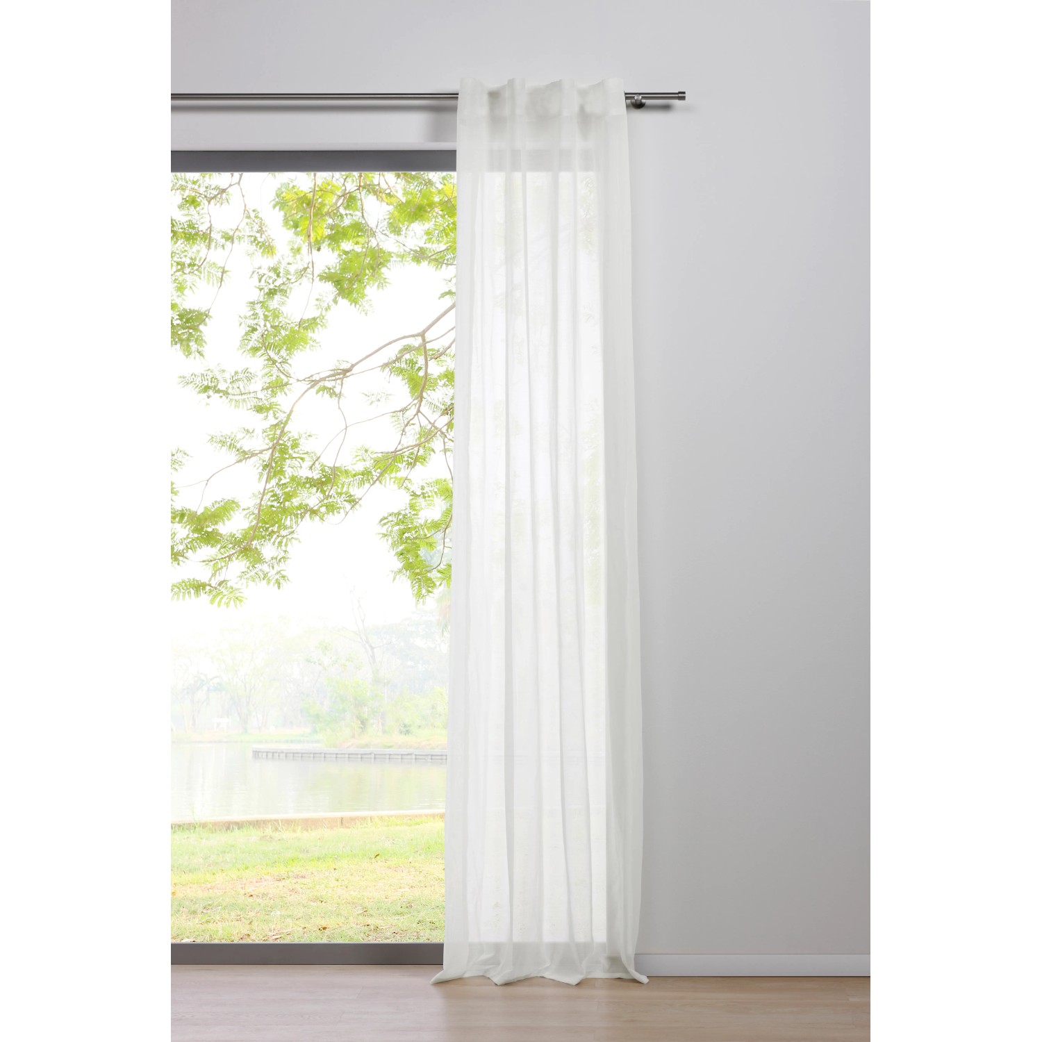 Mydeco Schlaufenschal Pure Weiß, 245x135 cm, halbtransparent vor Fenster mit Ausblick ins Grüne.