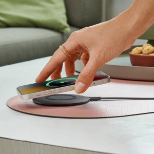 Hand legt Smartphone auf schwarzes Hama Wireless Ladepad. Kabelloses Laden mit 15W für Qi-fähige Handys.