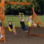 Kinder spielen auf dem Backyard Discovery Spielturm Atlantic mit Schaukel und Trapezstange.