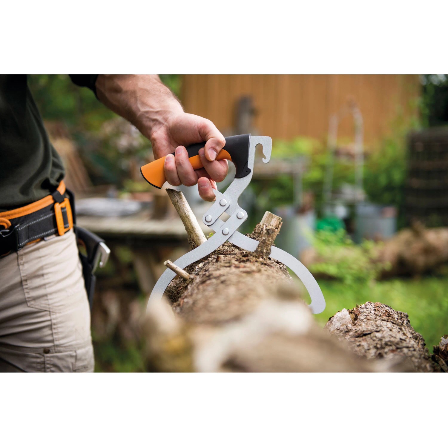 Fiskars WoodXpert Handpackzange beim Anheben eines Baumstamms. Gartenhelfer für Holz.