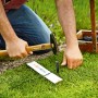 Gardena Mähroboter-Begrenzungskabel Installation mit Hammer und Hering im Garten.