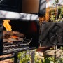 Jamestown Kombigrill Drake Holzkohlegrill mit Feuerholz und geöffneter Tür.