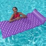 Frau entspannt auf lila Bestway Luftmatratze Float'n Roll im Pool.