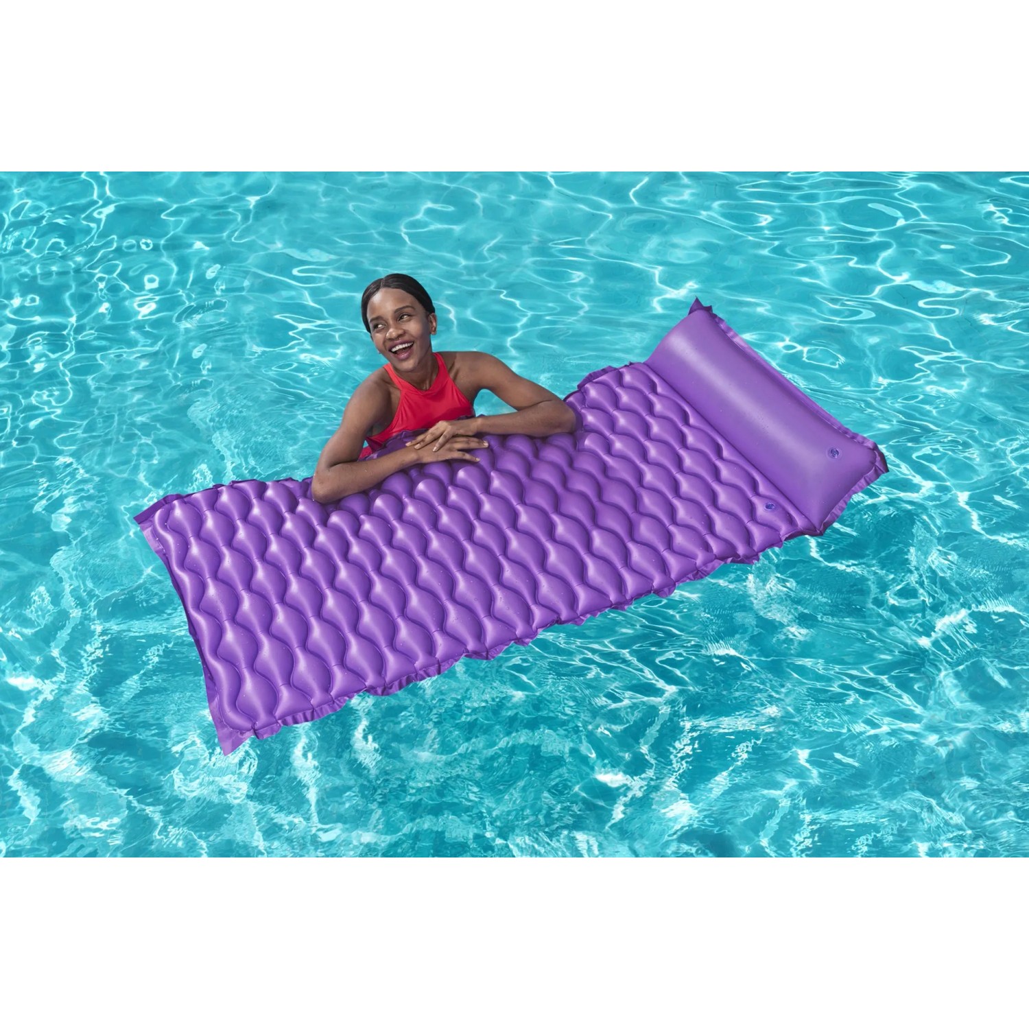 Frau entspannt auf lila Bestway Luftmatratze Float'n Roll im Pool.