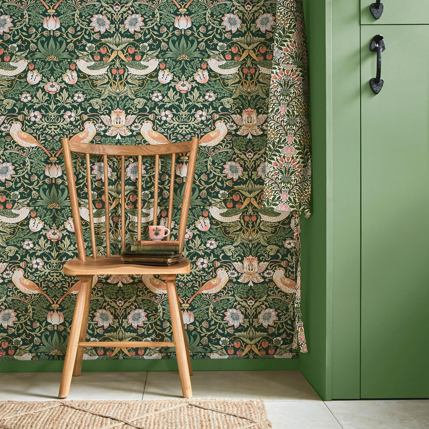 Grüne William Morris Vliestapete Strawberry Thief mit floralem Muster und Vogelmotiven.