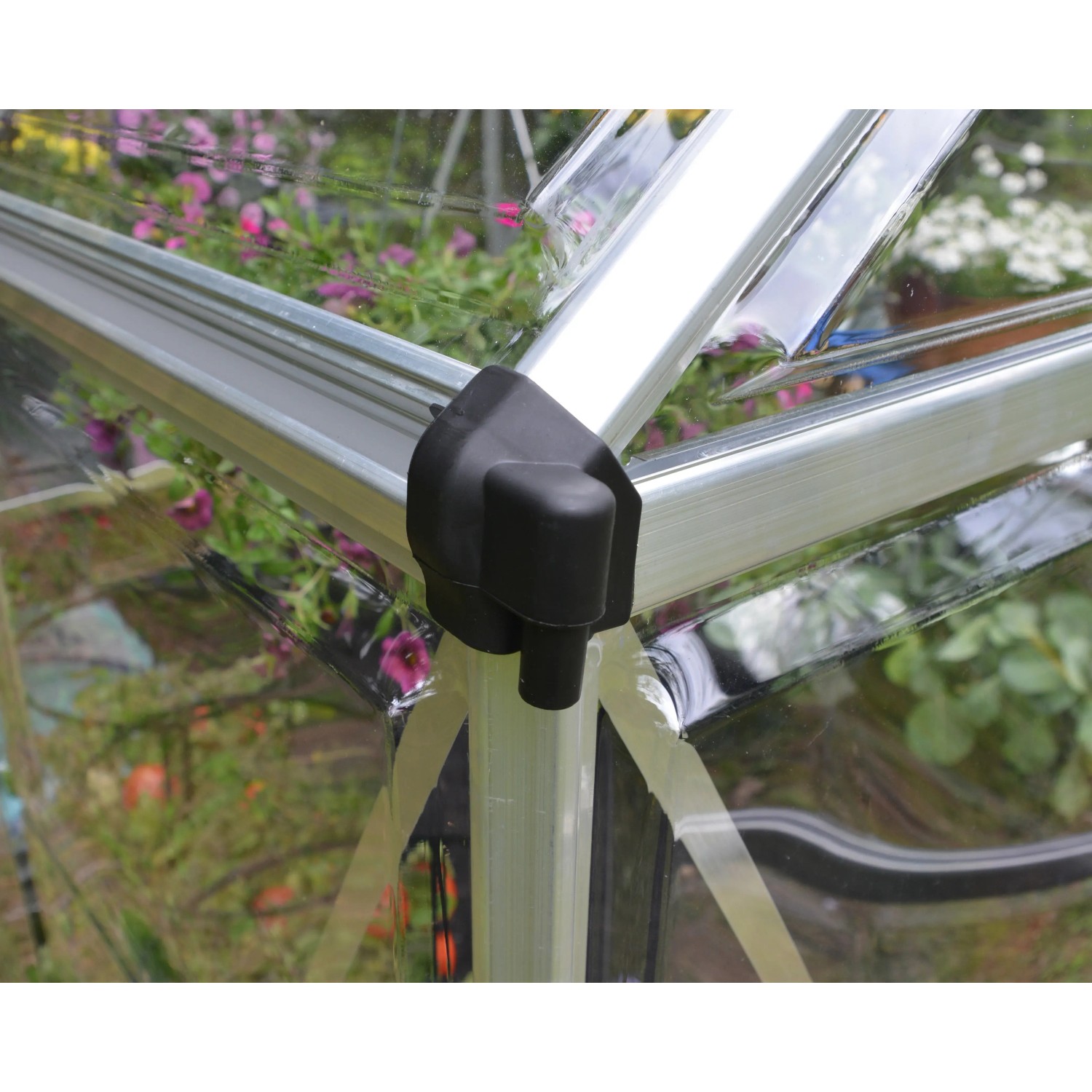 Detailaufnahme: Silbernes Palram Canopia Gewächshaus mit schwarzem Eckverbinder und transparenten Polycarbonatplatten.