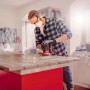 Mann schleift Holz mit Einhell Exzenterschleifer. Zubehör: Q-Stick Schleifpapier-Set Ø 125 mm.
