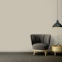 Wohnraum mit A.S. Création Vliestapete Ethnic Origin Uni Taupe, Sessel und Lampe.