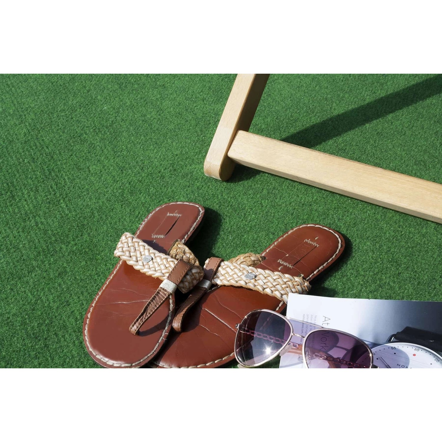 Primaflor Rasenteppich Comfort Anthrazit: Detailaufnahme mit Sandalen und Sonnenbrille auf dem Kunstrasen.