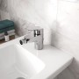 Ideal Standard Ceraflex Bidetarmatur in Chrom auf einem weißen Bidet montiert.