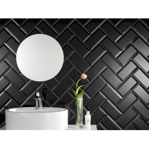 Glänzende, schwarze Wandfliese Facette Metro im Fischgrätmuster im Badezimmer.