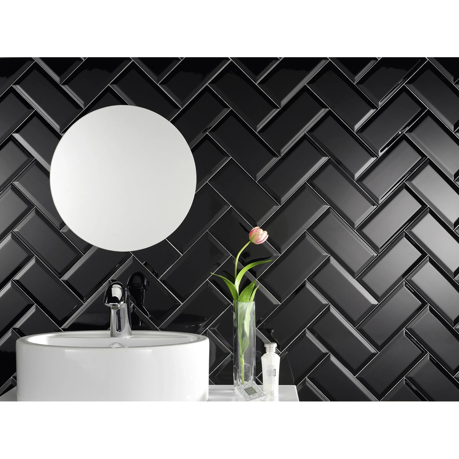 Glänzende, schwarze Wandfliese Facette Metro im Fischgrätmuster im Badezimmer.