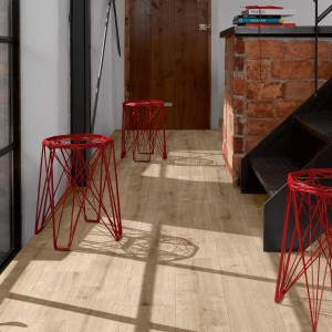 Verlegtes Laminat Parador Basic 200 Eiche Landhausdiele mit roten Hockern in modernem Raum.