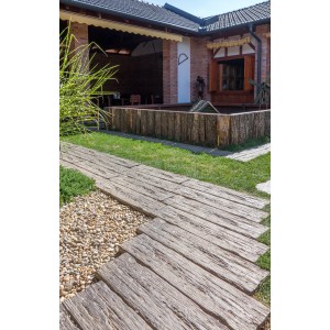 Braune EHL Bahnschwelle (90x22,5x5 cm) als rustikale Gehwegplatte im Garten.