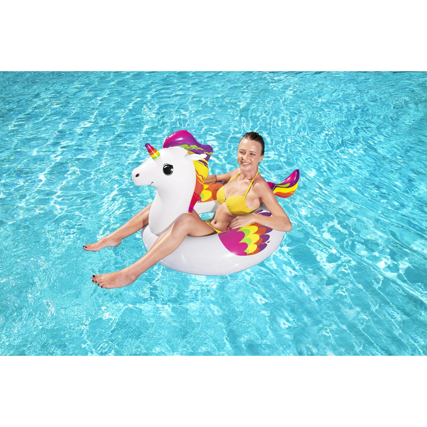 Frau auf Bestway Schwimmring Einhorn im Pool. Buntes Design, ideal für Wasserspaß im Sommer.