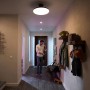 Szene mit Philips Hue Centura Einbauspots: Mann im Flur unter runden LED-Leuchten mit Farbwechsel.