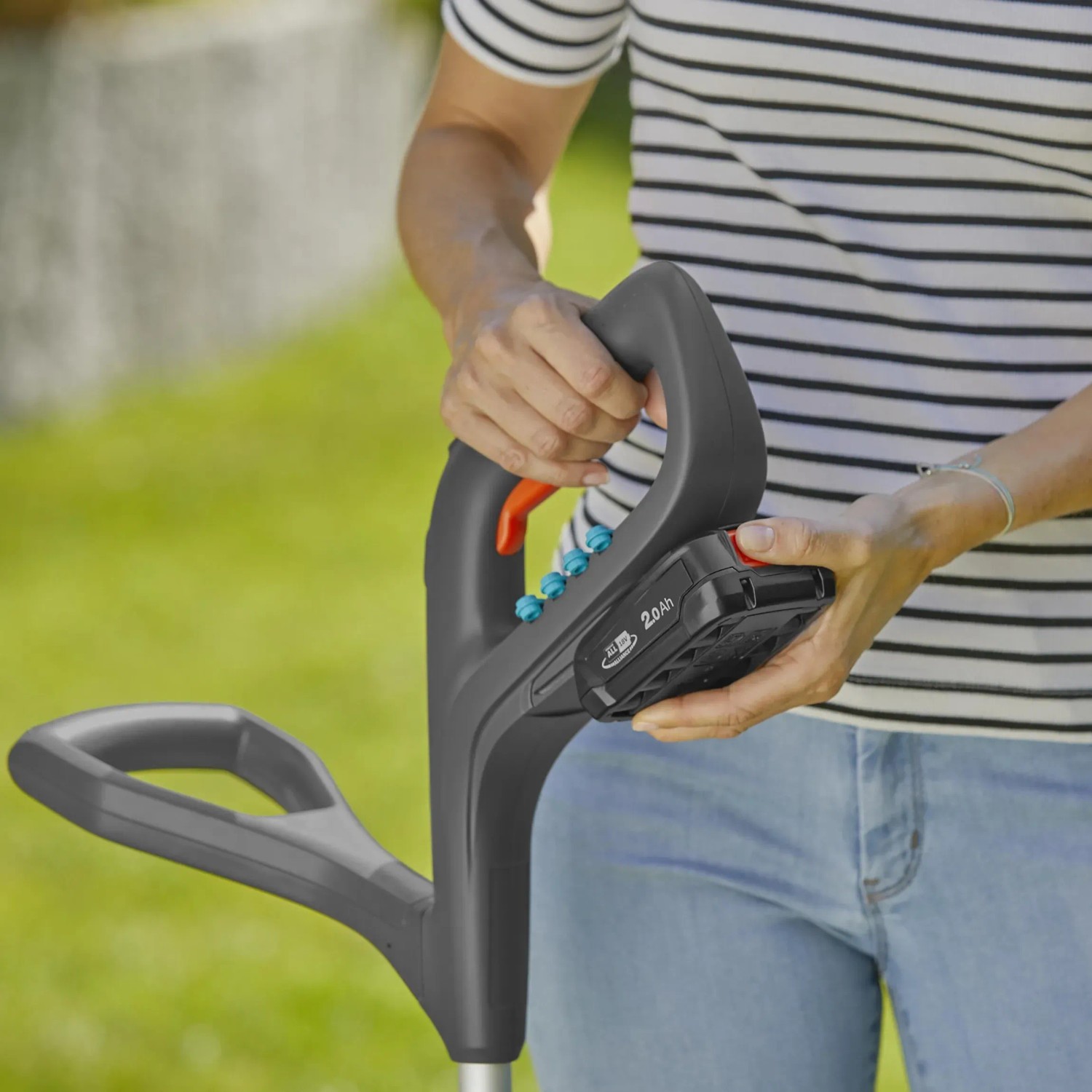 Gardena Akku-Trimmer SmallCut 23/18V: Akku wird eingesetzt. Ergonomischer Griff für komfortable Rasenpflege.