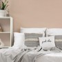 Beige Vliestapete von A.S. Création im Schlafzimmer mit Bett und Regal.