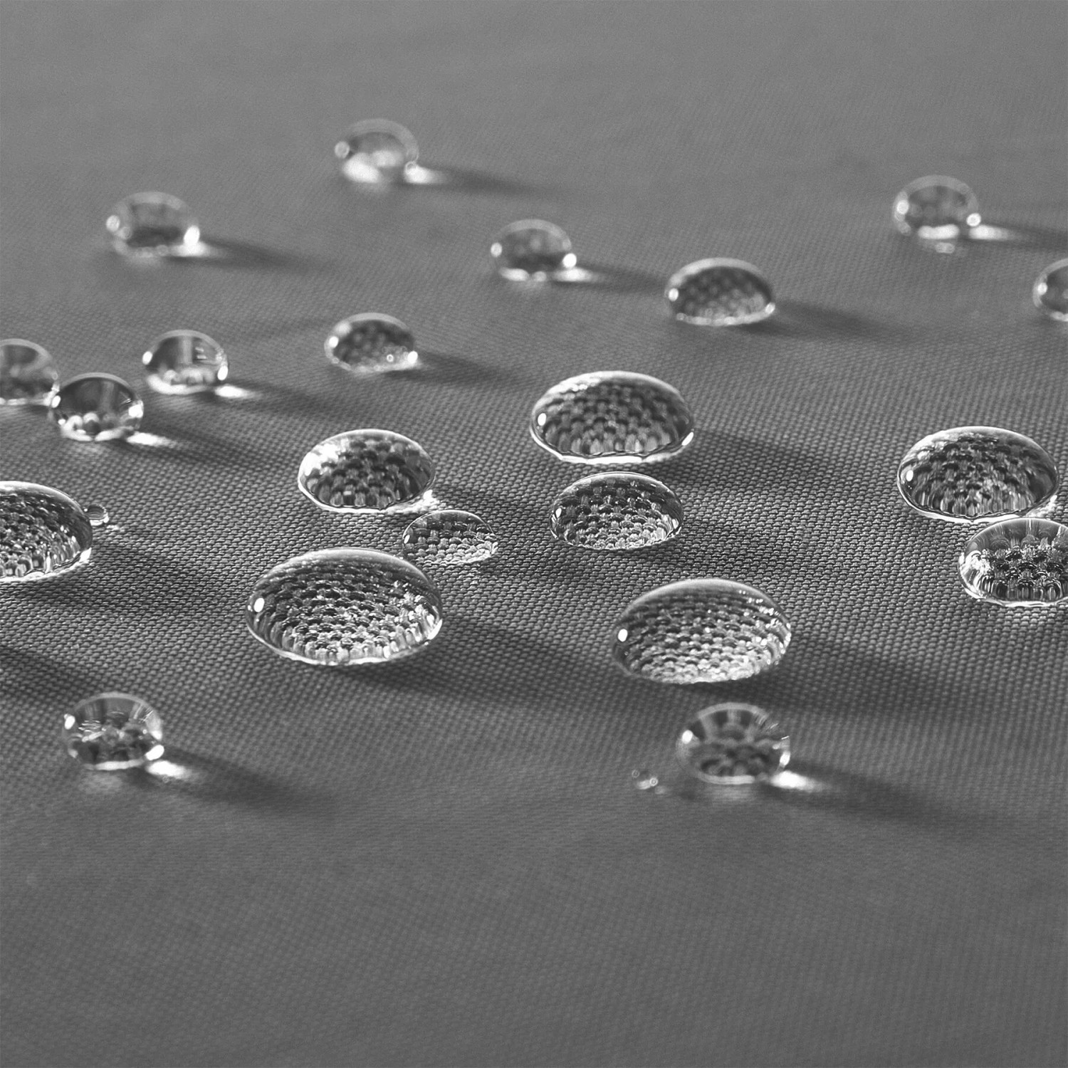 Wassertropfen perlen auf dem grauen, wasserabweisenden Polyesterbezug der Tectake Gartenstühle.