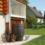 Garantia Regentonne Barrica 260 l in Dunkelbraun vor Hauswand mit Garten.
