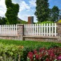Bruchsteinmauer Jura-Nuanciert mit weißem Zaun in Gartenlandschaft, 50x25x15 cm.