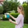 Frau nutzt Gardena combisystem Winkelbesen 23 cm im Garten zur Reinigung.