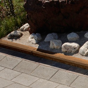 Brauner Tiefbordstein (100x20x8 cm) als Beet- und Wegeinfassung.