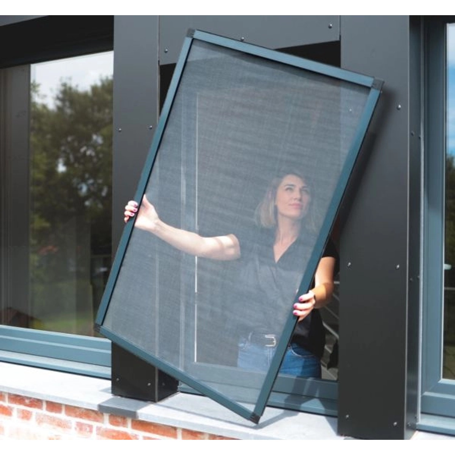 Frau montiert weißen Avosdim Fliegengitter-Rahmen (4er-Pack) am Fenster.